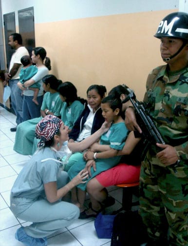 Examining a patient with a cleft palate in line for his operation at the military hospital in San Salvador.
